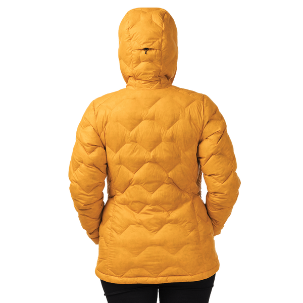 Person wearing a mustard yellow quilted jacket on a white background