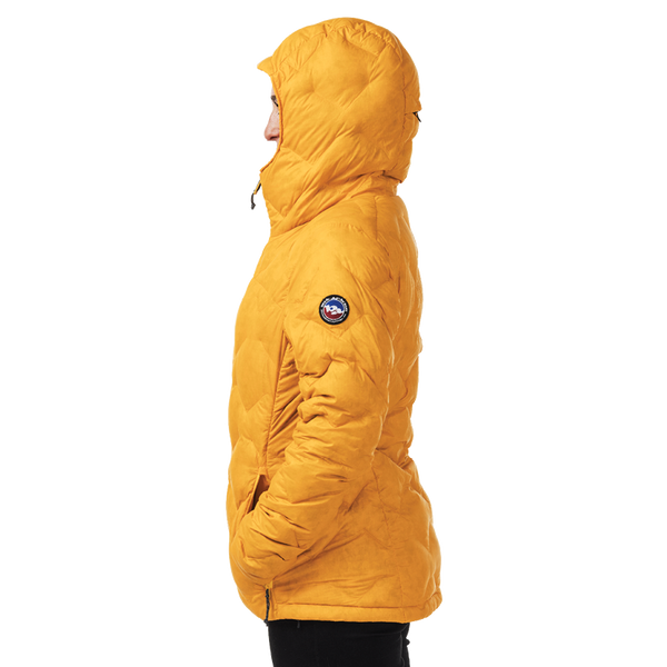 Person wearing a mustard yellow quilted jacket on a white background