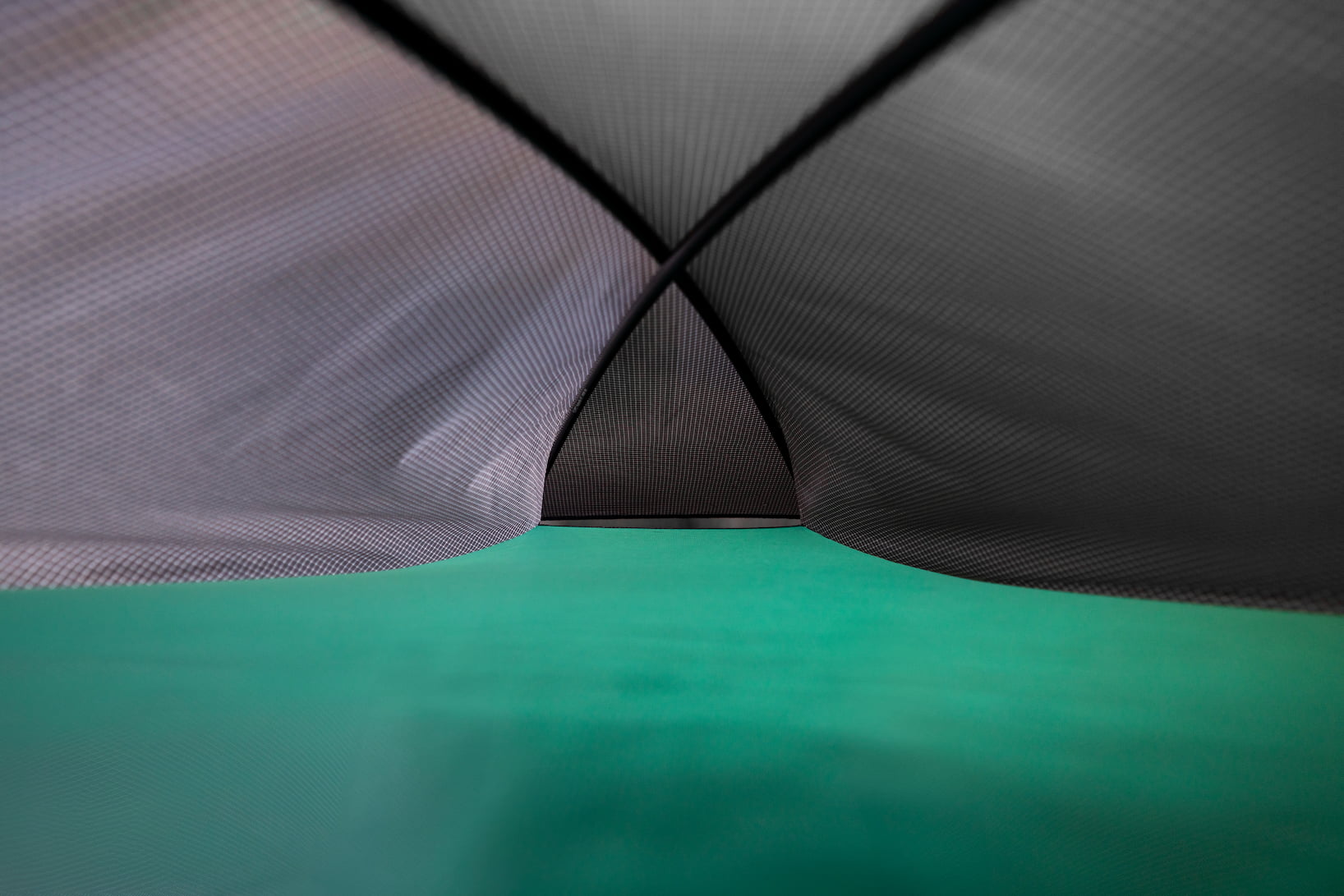 Close-up of a tent fabric with a geometric pattern on a green background