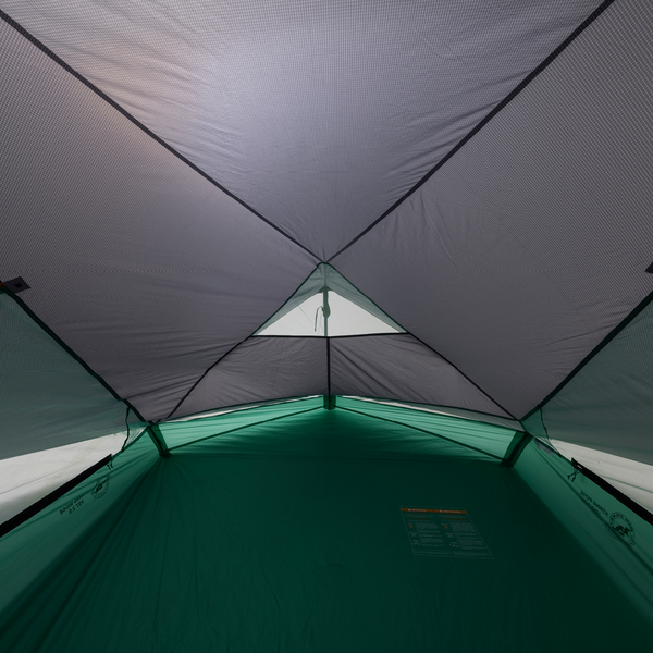 Inside view of a tent with green floor and gray walls